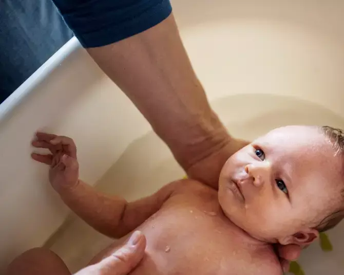 Padre bañando a su bebé